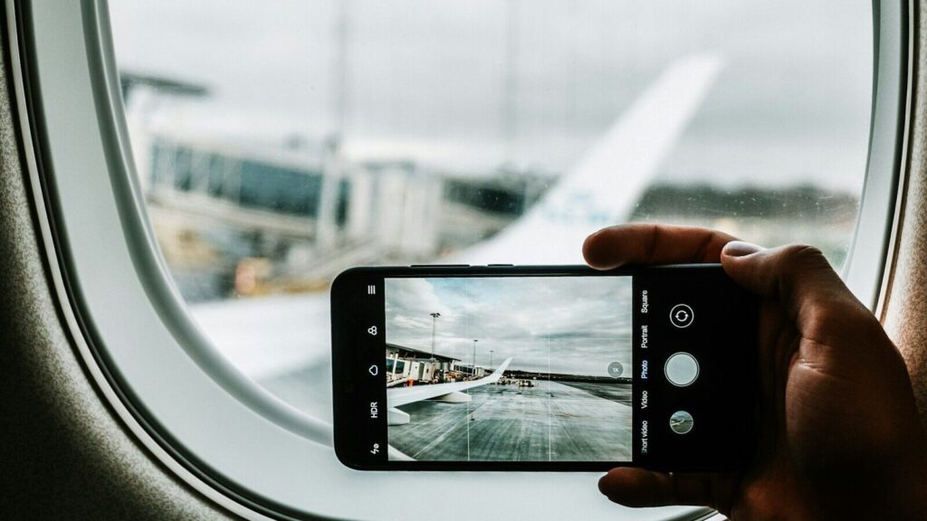 black iPhone capturing plane wing