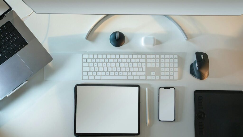a desk with a computer, keyboard, mouse, and other items