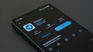 A phone screen displays the telegram app.