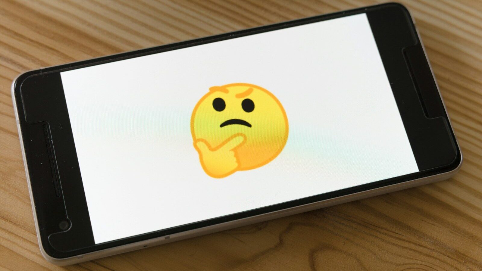 black flat screen tv turned on displaying yellow emoji