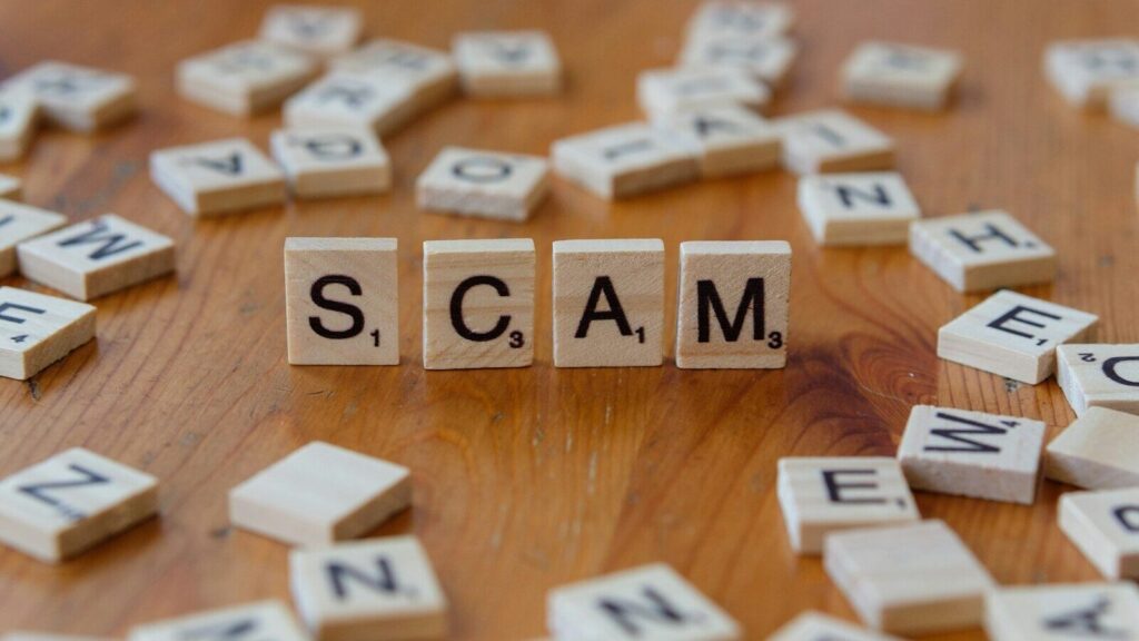 Scam spelled with scrabbles on a wooden table