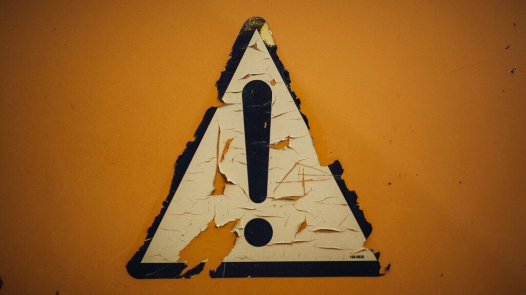 a triangle shaped sign on a yellow wall